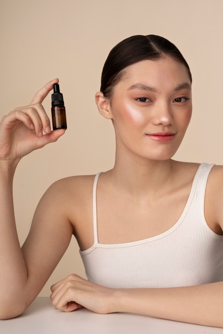 Foto grátis mulher coreana de tom médio posando com uma garrafa de soro