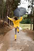 Foto grátis mulher correndo na floresta, segurando um guarda-chuva