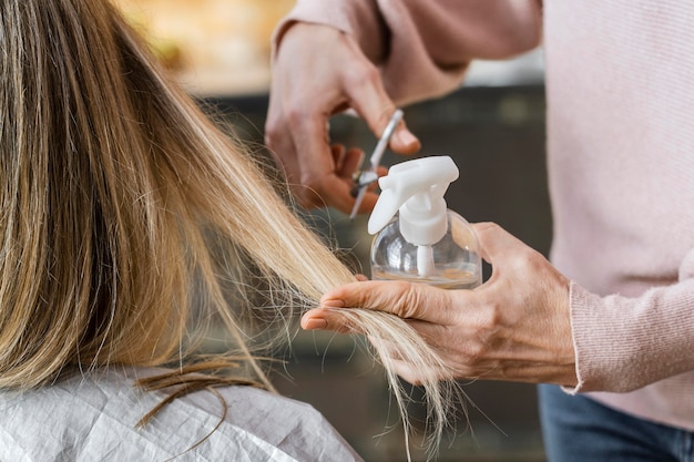 Mulher cortando cabelo em casa de cabeleireiro