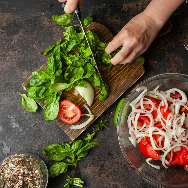 Mulher cortando espinafre para vista superior da salada sazonal