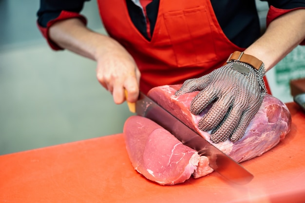 Mulher, corte, carne fresca, em, um, açougue, loja, com, metal, segurança, malha, luva