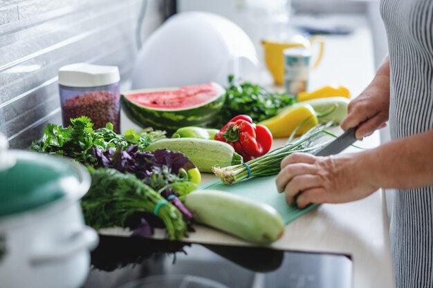 Mulher cozinhando legumes na cozinha.