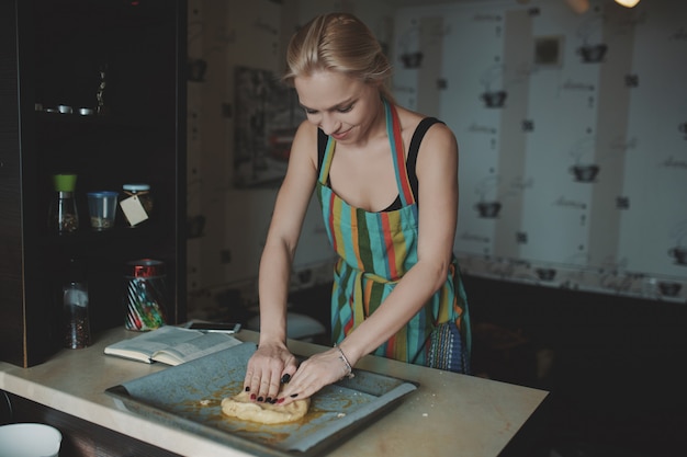 Mulher cozinhando pizza na cozinha