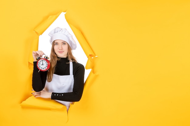 Mulher cozinheira com boné de cozinheira branca segurando o relógio na cor amarela trabalho emoção comida cozinha foto sol
