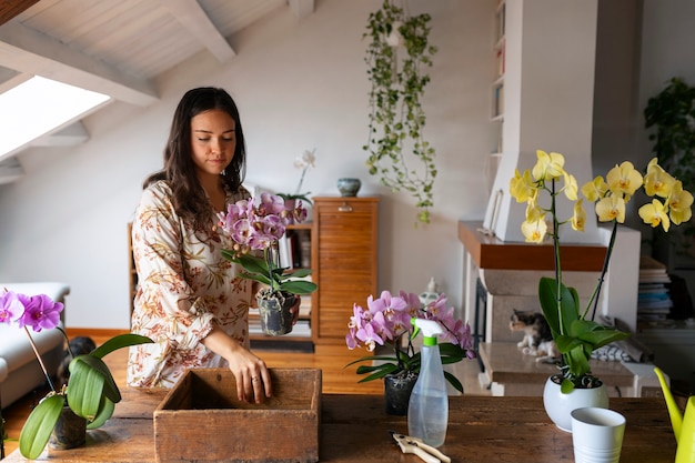 Foto grátis mulher cuidando de orquídeas exóticas