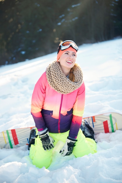 Mulher curtindo snowboard na colina