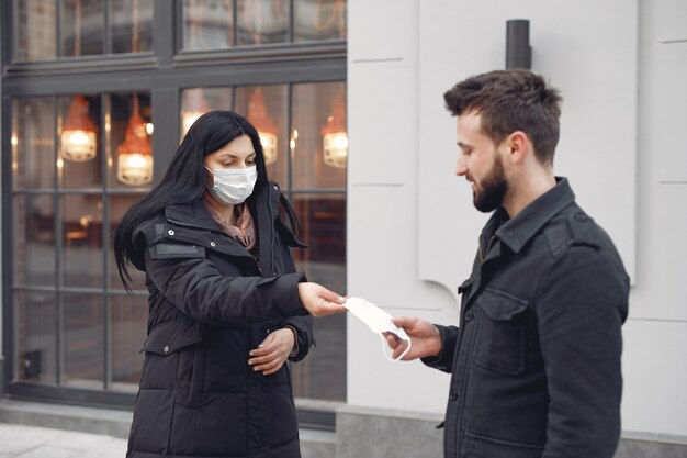 Mulher dando máscara protetora para um homem