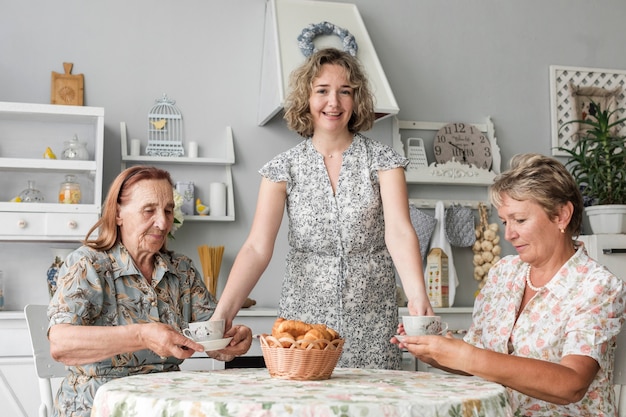 Foto grátis mulher, dar, xícara café, para, dela, mãe, e, vovó, em, cozinha