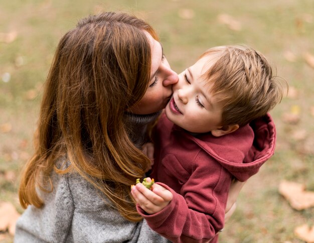 Mulher de alto ângulo beijando filho