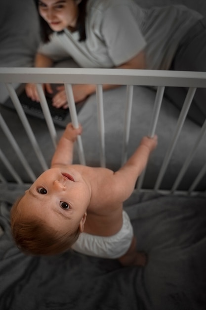 Foto grátis mulher de alto ângulo com bebê trabalhando no laptop