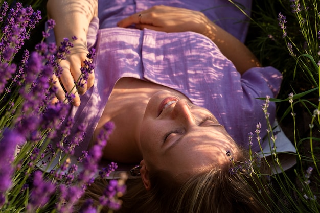 Mulher de alto ângulo deitada no campo de lavanda