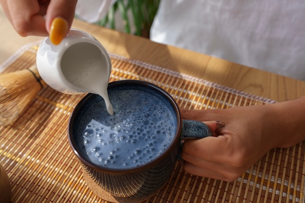 Foto grátis mulher de alto ângulo desfrutando de matcha azul em casa