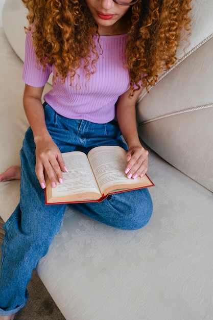 Mulher de alto ângulo lendo em casa