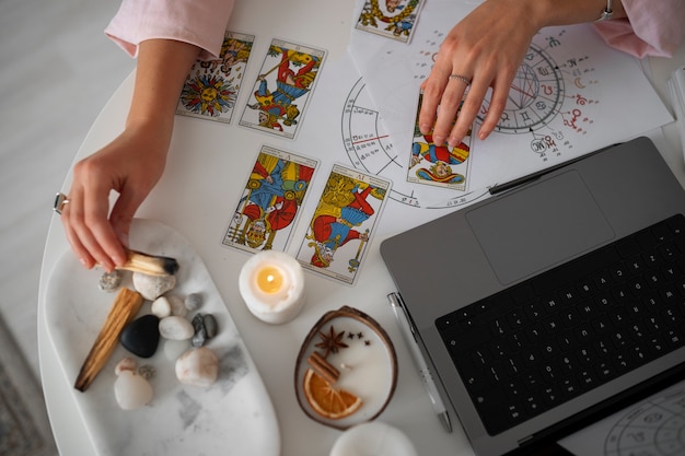 Foto grátis mulher de alto ângulo lendo tarô com laptop