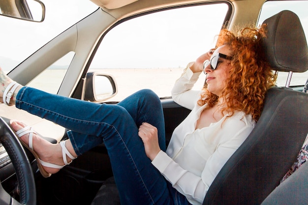 Mulher de alto ângulo no carro descansando