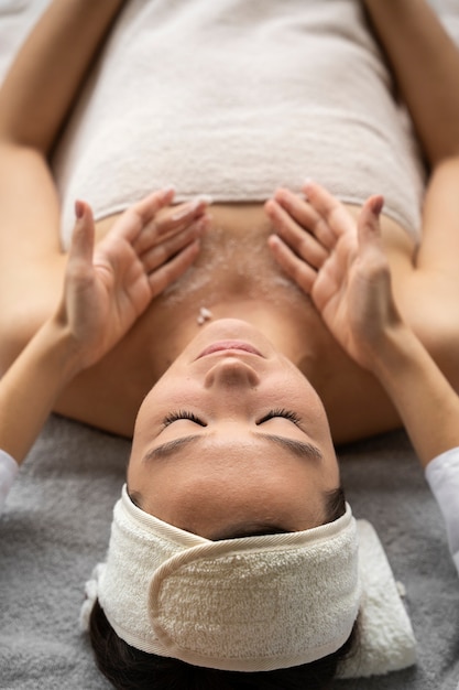 Mulher de alto ângulo sendo massageada no spa