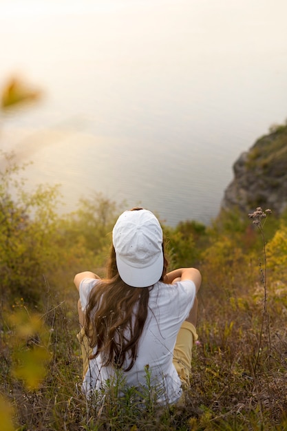 Foto grátis mulher de alto ângulo sentada na natureza