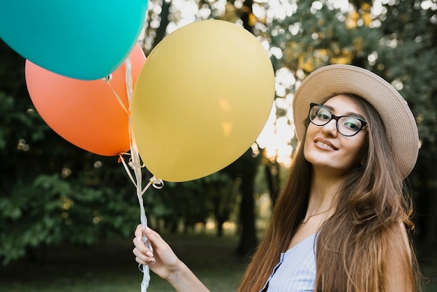 Mulher de aniversário com chapéu, olhando para a câmera