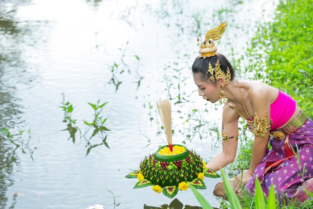 Mulher de ásia em vestido tailandês tradicional segurar kratong. festival loy krathong