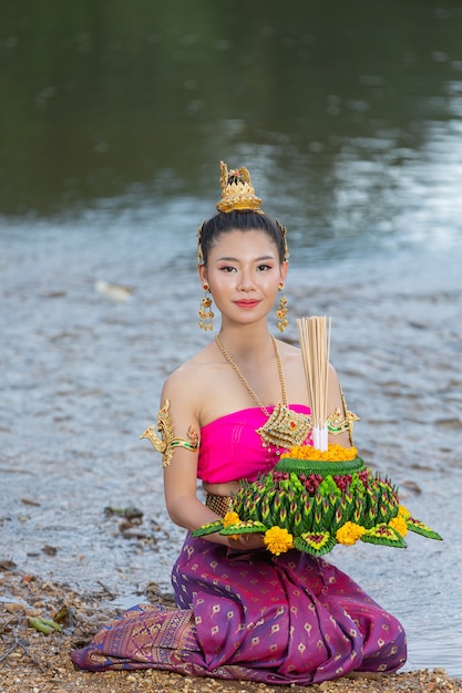 Mulher de ásia em vestido tailandês tradicional segurar kratong. festival loy krathong