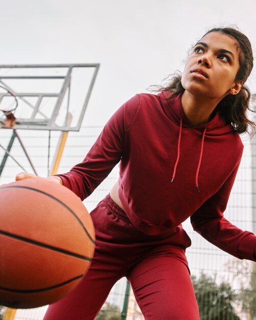 Mulher de baixo ângulo jogando basquete