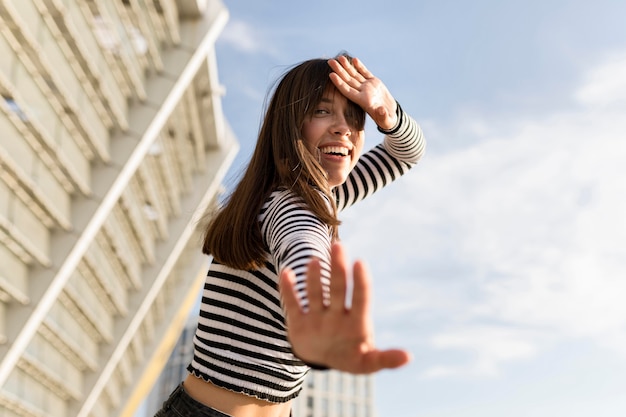 Mulher de baixo ângulo, olhando feliz ao ar livre