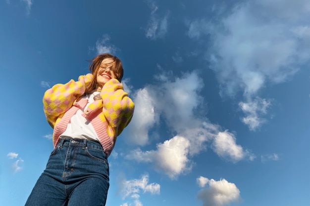 Foto grátis mulher de baixo ângulo posando ao ar livre