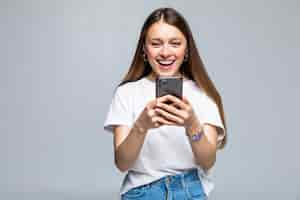 Foto grátis mulher de beleza usando e lendo um smartphone isolado