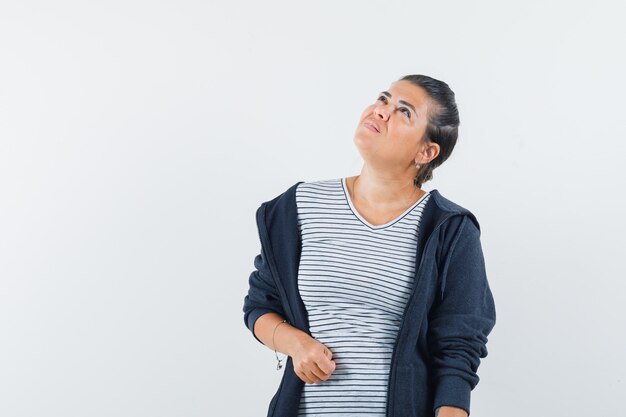 Mulher de cabelo escuro olhando para cima com a camisa