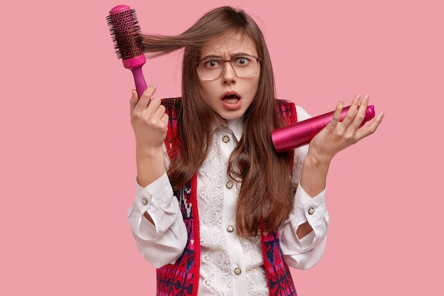 Mulher de camisa branca arrumando o cabelo