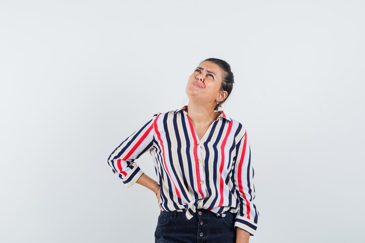 Foto grátis mulher de camisa, saia olhando para cima e parecendo hesitante