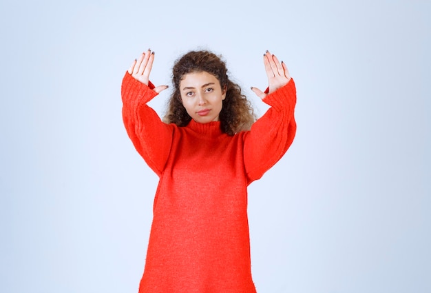 Mulher de camisa vermelha, parando e impedindo algo.