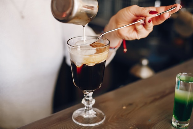 Mulher de camisola branca, derramando leite na sobremesa de café