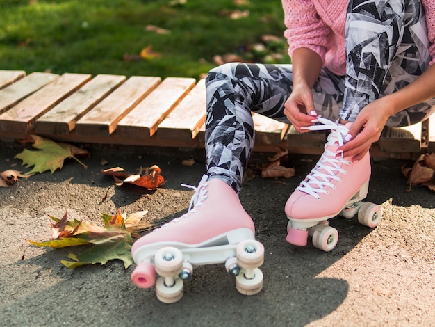 Foto grátis mulher de caneleiras, amarrando o cadarço no skate com espaço de cópia