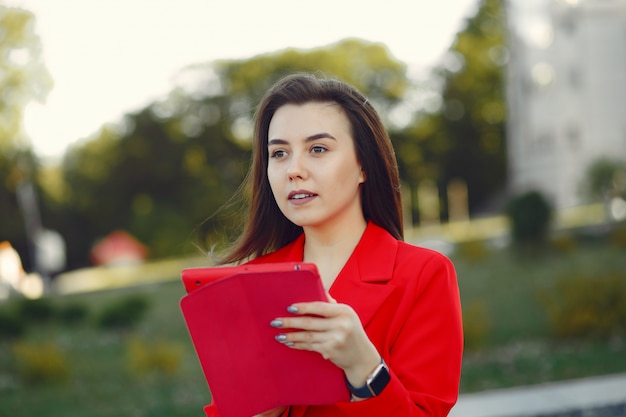 Mulher de casaco vermelho usando um tablet