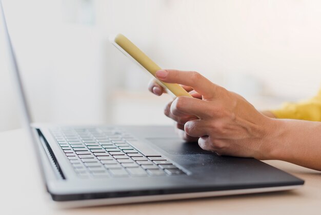 Mulher de close-up com laptop e smartphone