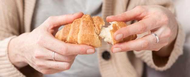 Foto grátis mulher de close-up, desfrutando de croissant