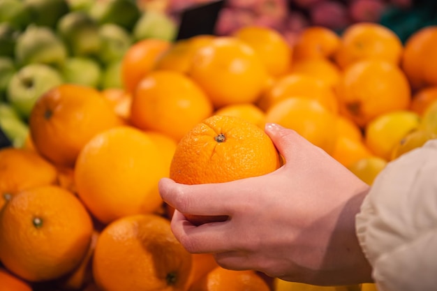 Foto grátis mulher de close-up escolhendo laranja na mercearia