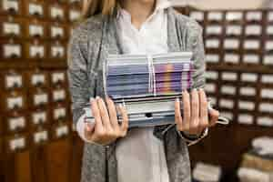 Foto grátis mulher de colheita com pilha de livros e cadernos