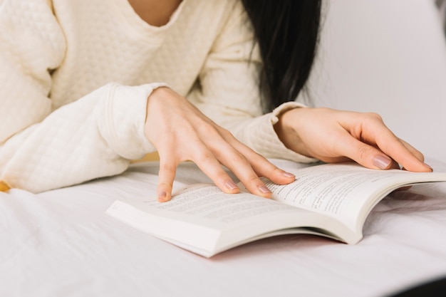 Mulher de colheita lendo um bom livro na cama