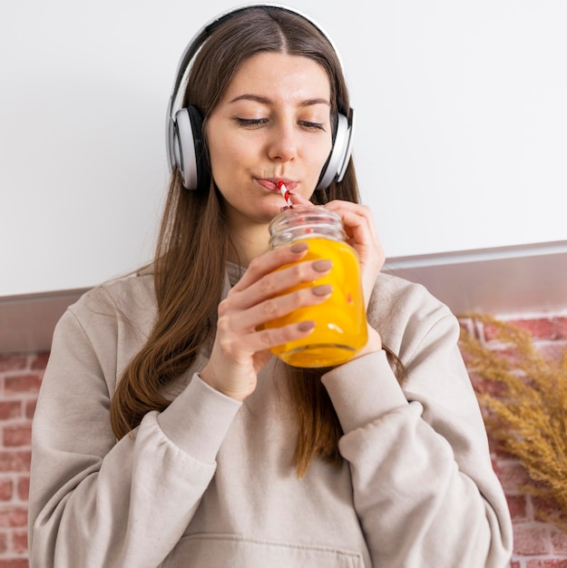 Foto grátis mulher de dose média bebendo suco