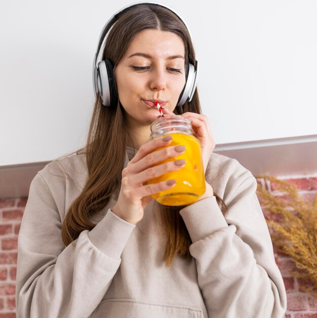 Mulher de dose média bebendo suco