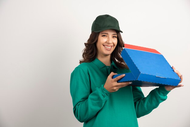 Mulher de entrega feliz abrindo a caixa de pizza em branco.