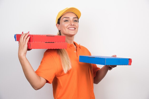 Mulher de entrega feliz segurando caixas de pizza.