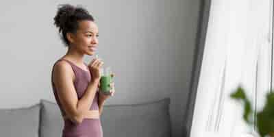 Foto grátis mulher de fitness tomando um suco de fruta