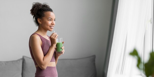 Mulher de fitness tomando um suco de fruta