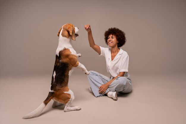 Mulher de foto completa com cachorro em estúdio