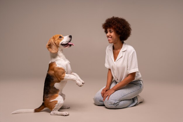 Foto grátis mulher de foto completa com cachorro em estúdio