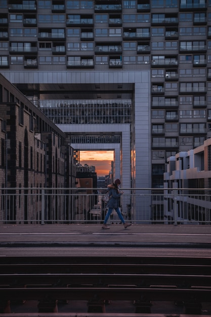 Mulher de jaqueta azul e jeans azul andando na calçada