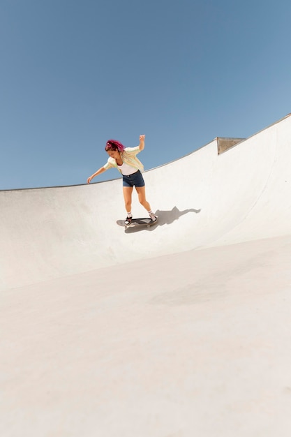 Mulher de longo alcance com skate